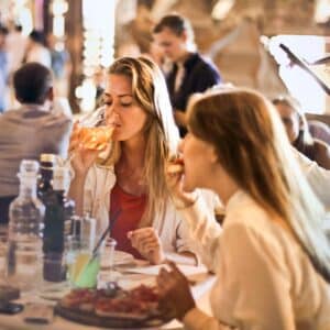 Women drinking wine and eating food