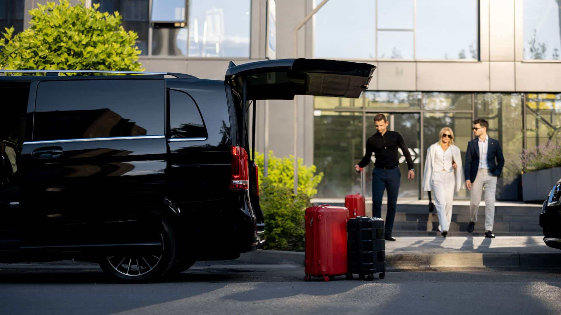 People approaching a car while carrying luggage