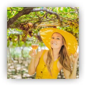 Woman wearing yellow and drinking wine