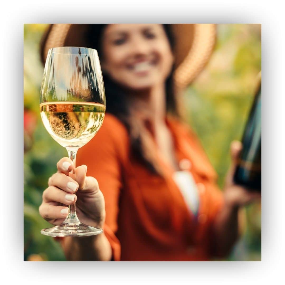 woman holding wine glass, all out of focus except for hand/glass