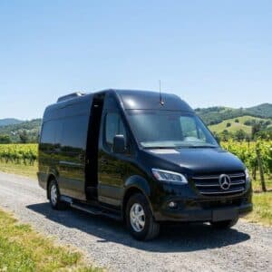 A black luxury Sprinter van parked on a vineyard road in Edna Valley.